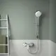 Brausearmatur von Ideal Standard an einer Wand mit grüner Farbe, in einem Badezimmer mit weißen Fliesen und einer Handtuchleiter in der Nähe.
